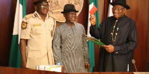 L-R: COMPTROLLER-GENERAL, NIGERIA IMMIGRATION SERVICE-DAVID SHIKFU PANADANG, INTERIOR MINISTER-COMRADE ABBA MORO, WITH PRESIDENT GOODLUCK JONATHAN, LAUNCHING THE NEW 64-PAGE TRAVEL PASSPORT.