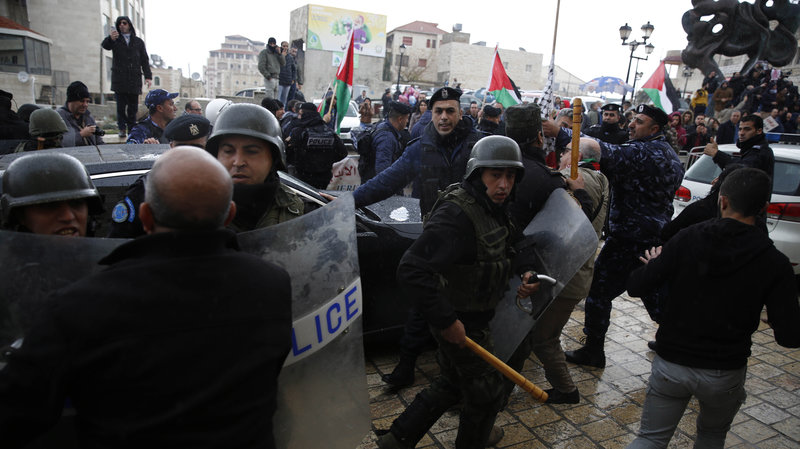 Palestinian security forces push away demonstrators from the convoy of Greek Orthodox Patriarch of Jerusalem Theophilos III, during a protest against his visit to the Church of the Nativity in the West Bank city of Bethlehem on Saturday. Majdi Mohammed/AP 